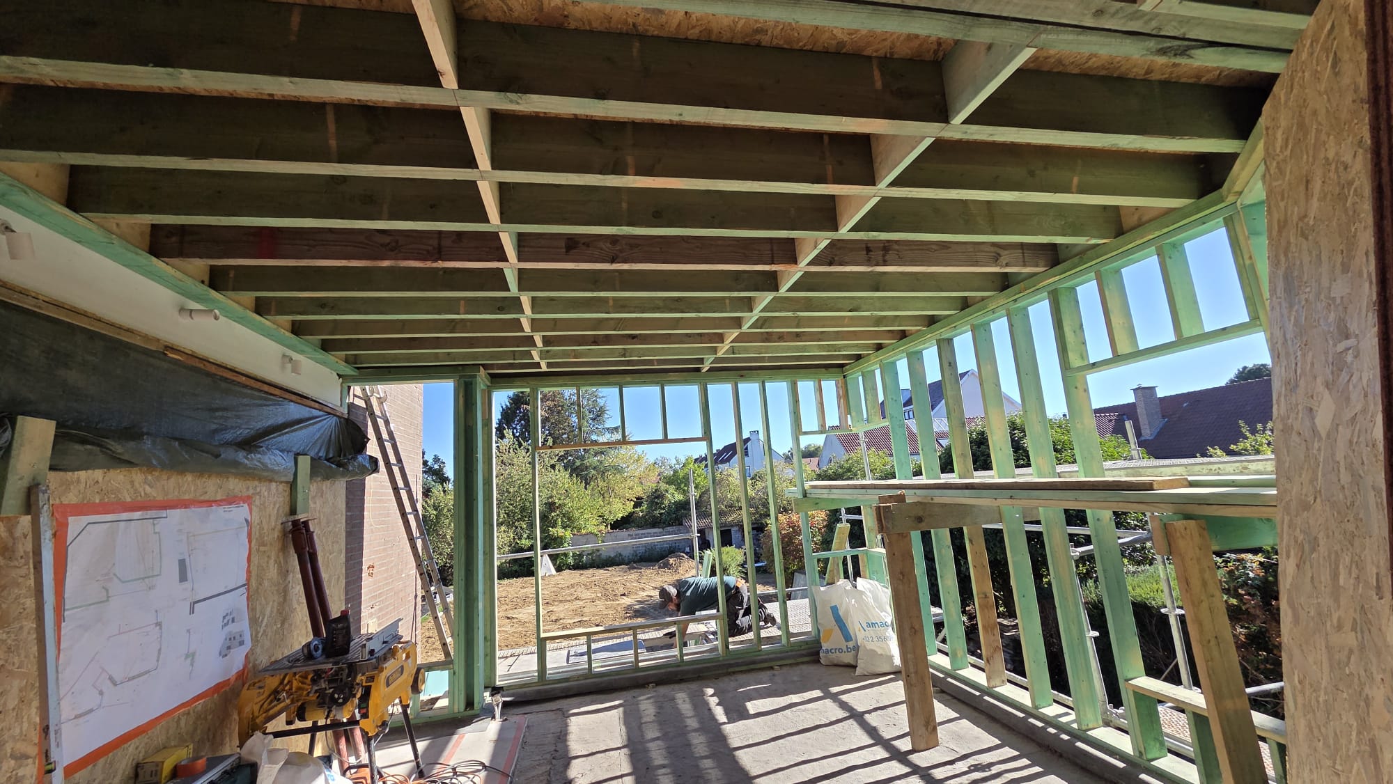 Semal — vue intérieure du chantier, ossature bois et ouverture sur le jardin